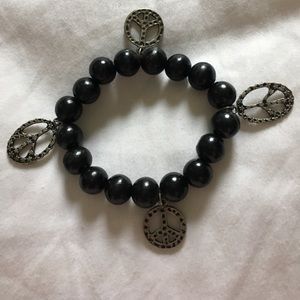 Black beaded bracelet with peace signs.